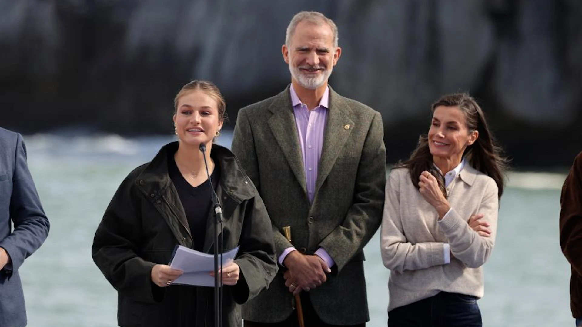 La princesa Leonor hablando ante un micrófono con un documento en las manos, acompañada por el rey Felipe VI y la reina Letizia en una visita institucional en Asturias.