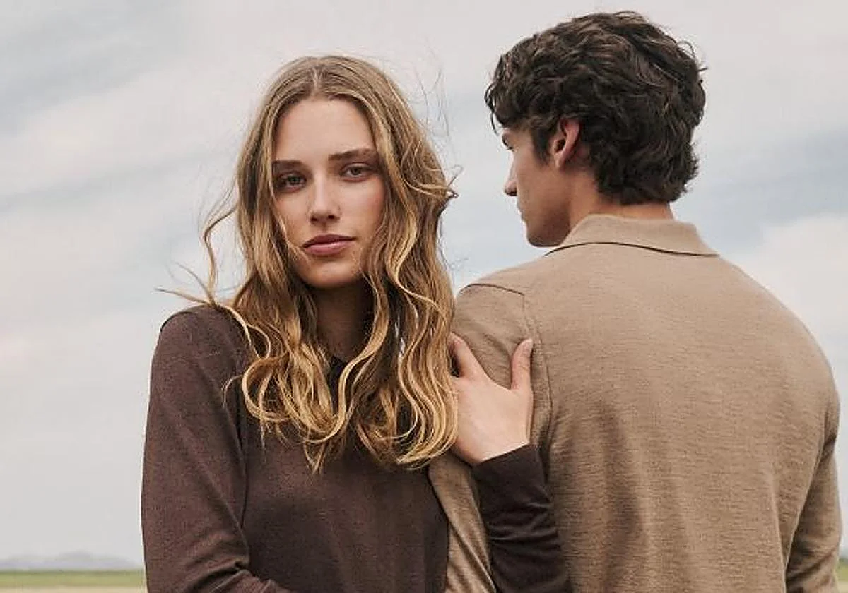 Fotografía publicitaria de moda mostrando a una modelo rubia de perfil con jersey marrón oscuro junto a un hombre de espaldas con jersey beige de cachemira de la firma Falconeri.