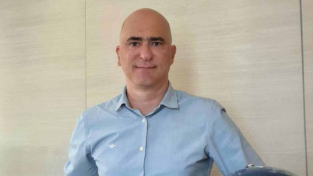 Retrato corporativo de Guy Leclercq, CEO de Deveho Consulting Group, con camisa azul y fondo neutro.