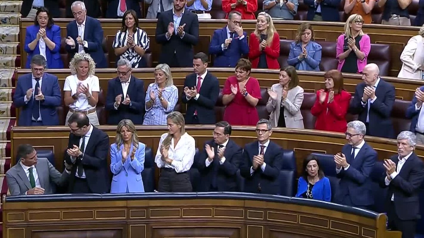 Diputados y miembros del Gobierno aplaudiendo en el hemiciclo del Congreso de los Diputados durante una sesión.