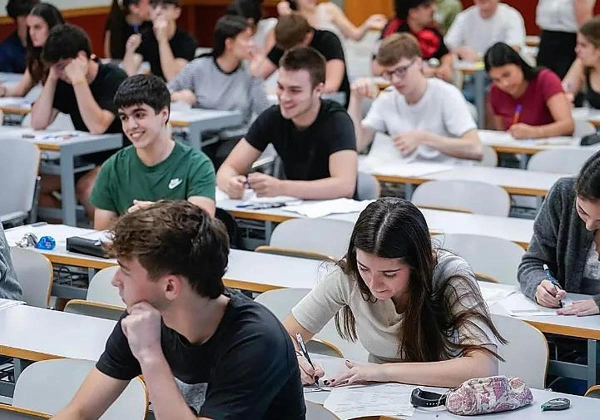 Estudiantes realizando exámenes en un aula universitaria.
