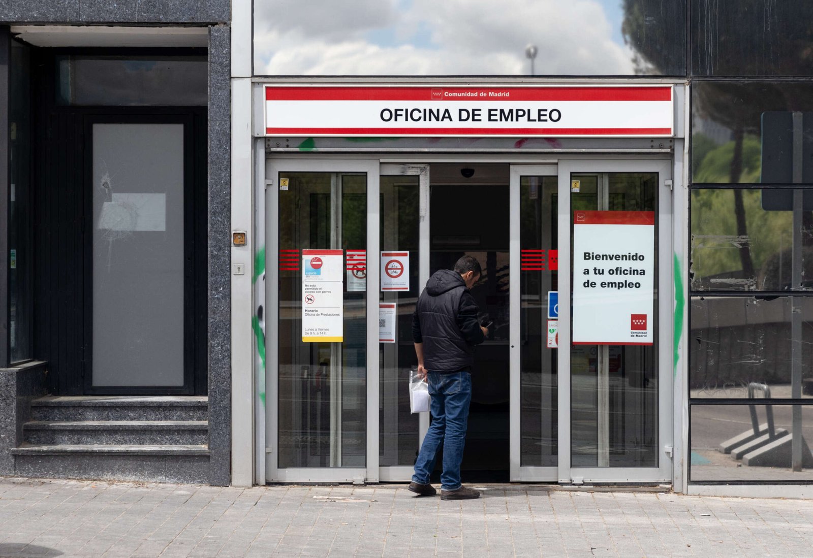 Hombre de espaldas accediendo a una oficina de empleo de la Comunidad de Madrid.