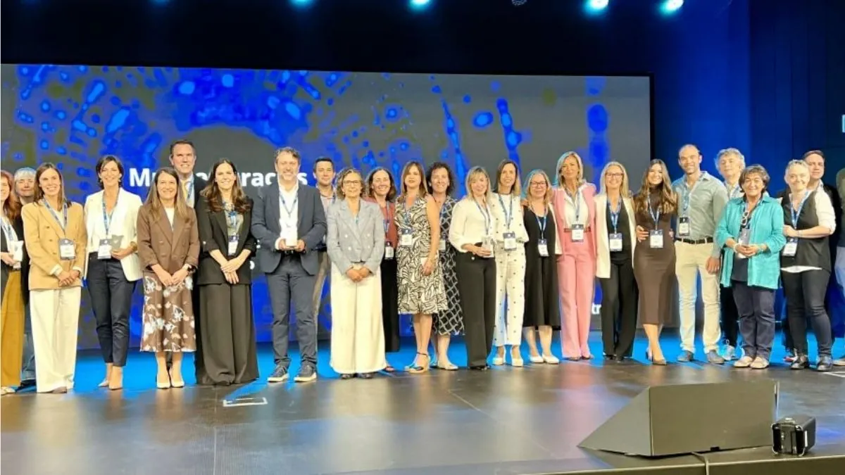 Fotografía editorial de grupo de profesionales sanitarios posando sonrientes en un escenario tras recibir múltiples premios hospitalarios Top 20.