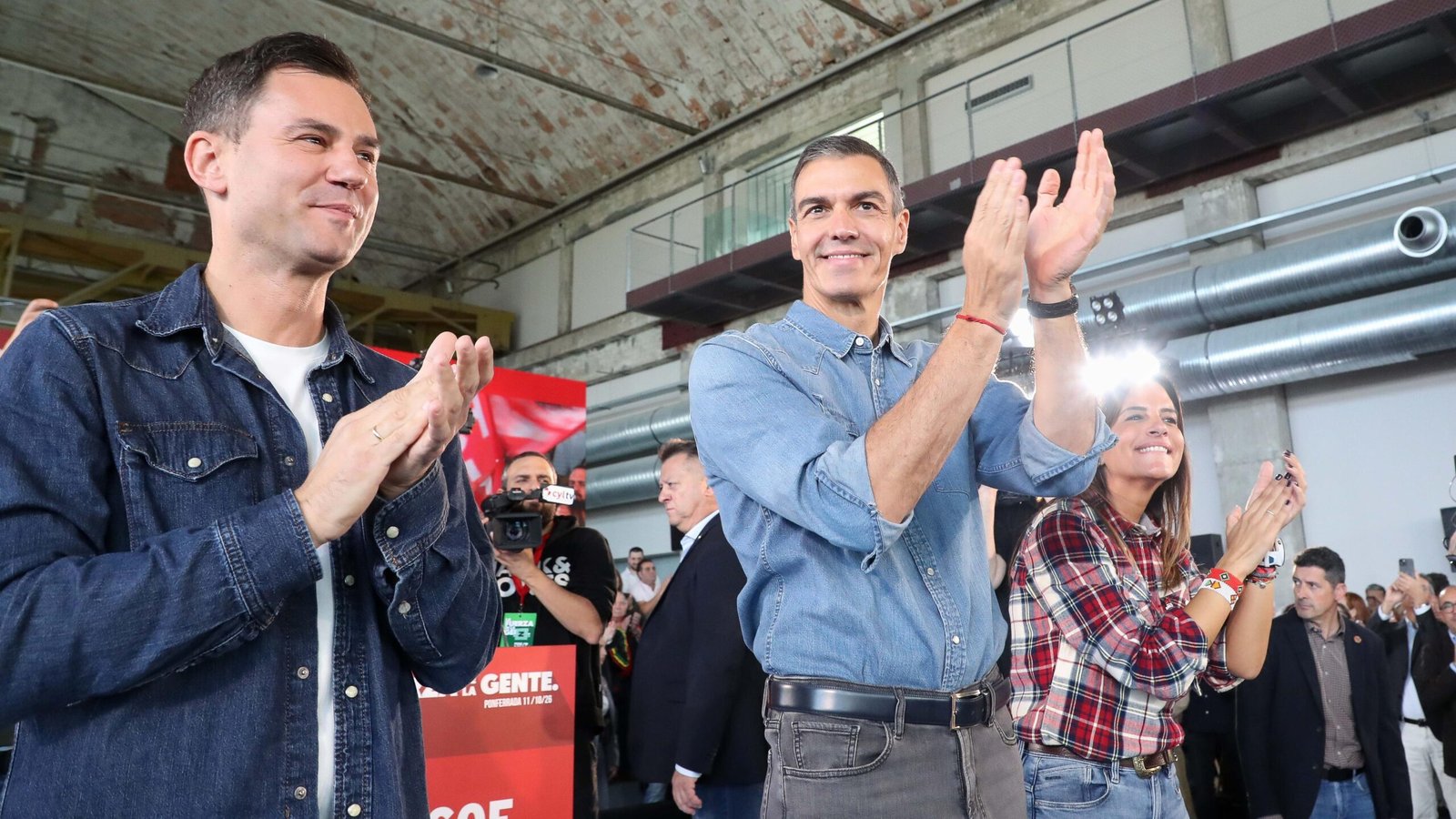 El presidente del Gobierno, Pedro Sánchez, junto a otros cargos políticos aplaudiendo en un acto público.